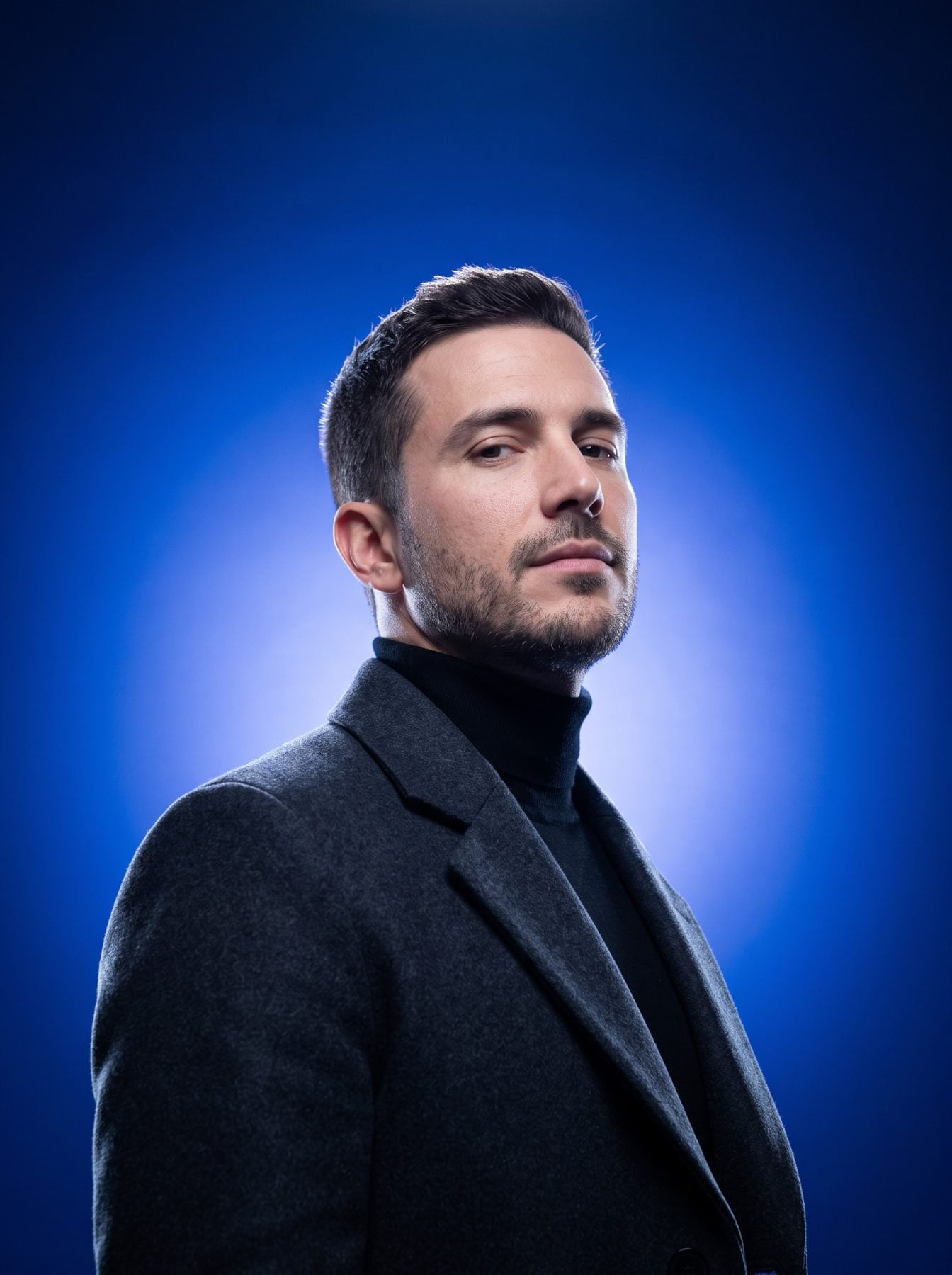 Editorial male portrait in a dark coat and turtleneck, vivid blue studio lighting, created with a ChatGPT and Gemini AI Prompt.