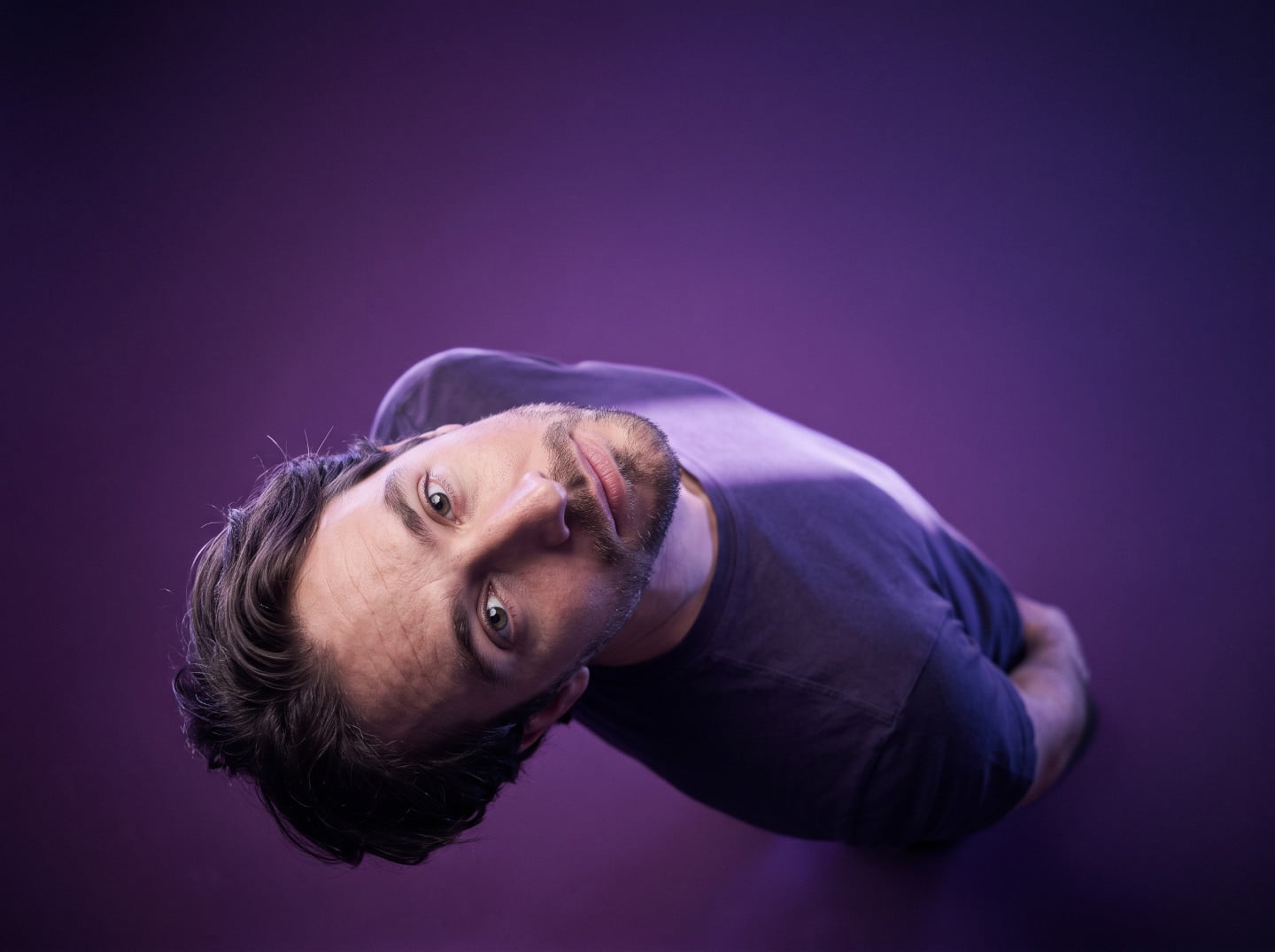 Male portrait in a purple studio, tilted sideways with dramatic lighting, created using an AI Prompt for ChatGPT and Gemini.