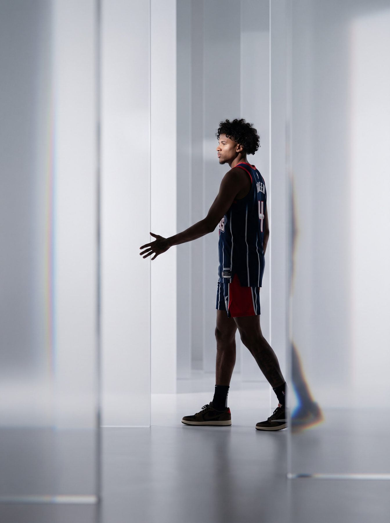Athlete in a dark sports jersey walks through reflective white panels, created with an AI Prompt for ChatGPT and Gemini.