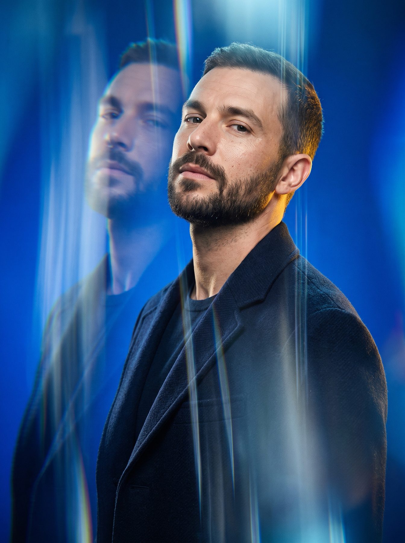 Bearded man in a dark blazer with a ghosted reflection in blue neon, made using an AI Prompt for ChatGPT and Gemini.